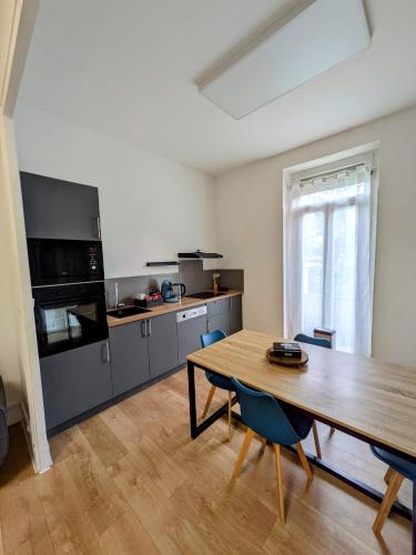 - une grande cuisine avec une table en bois et une table sidx sidx sidx dans l'établissement Maison de ville Marmande, à Marmande