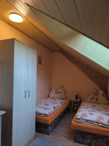 two twin beds in a room with a loft at Apartmány Hudec in Zuberec