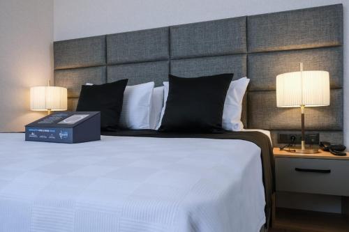 a bedroom with a large white bed with two lamps at Brand Business Hotel in Corlu