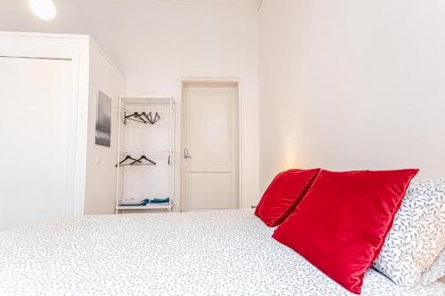 a white bedroom with a red pillow on a bed at Spacious Shared 5BR Apt in the Heart of Gent in Ghent