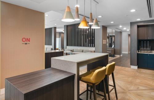 una hall di un ufficio con un bar con sedie gialle di TownePlace Suites Jacksonville Airport a Jacksonville