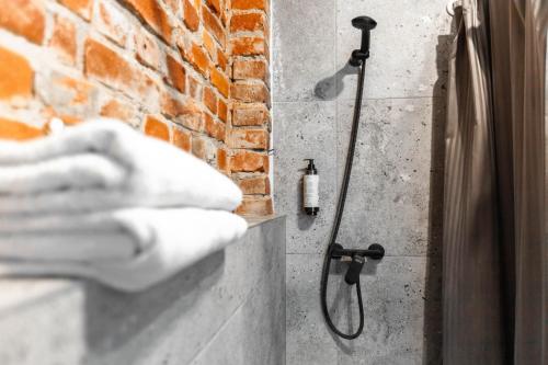 a shower with a hose in a brick wall at Old brick boutique apartments in Klaipėda