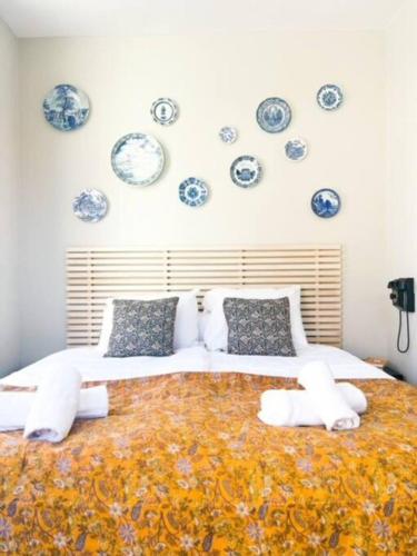 a bedroom with a large bed with blue and white plates on the wall at 3P comfortable apt next to Fontys in citycenter in Tilburg