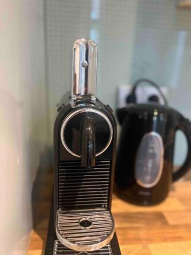 a black toaster sitting on a table with a cup at 3P comfortable apt next to Fontys in citycenter in Tilburg