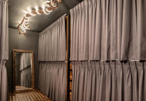 a room with grey curtains and a mirror at Homestal California Hostal en Tlaquepaque in Guadalajara