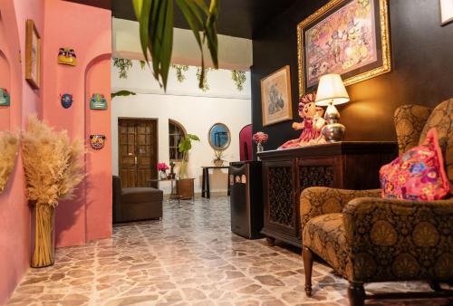a living room with pink walls and a chair at Homestal California Hostal en Tlaquepaque in Guadalajara