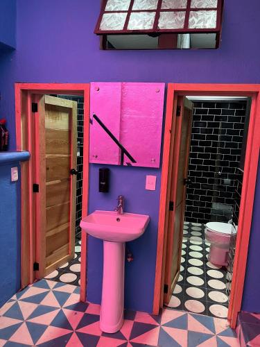 a bathroom with a pink sink and a toilet at Homestal California Hostal en Tlaquepaque in Guadalajara
