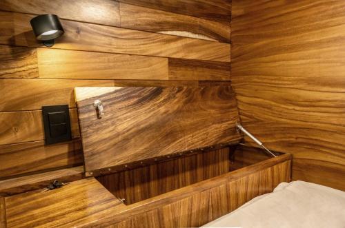 a room with wooden walls and a person standing in the mirror at Homestal California Hostal en Tlaquepaque in Guadalajara