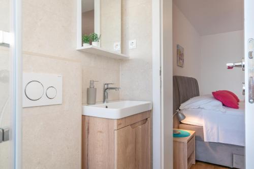 a bathroom with a sink and a bed at Apartments Malina in Tučepi