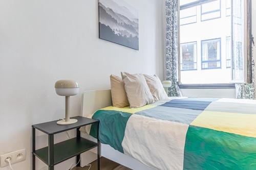 a bedroom with a bed and a lamp on a table at Spacious Shared 5BR Apt in the Heart of Gent in Ghent