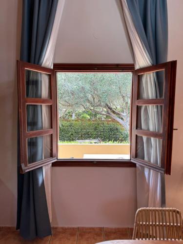 a window with a view of a tree at Psamathi Living & Taste in Marathi