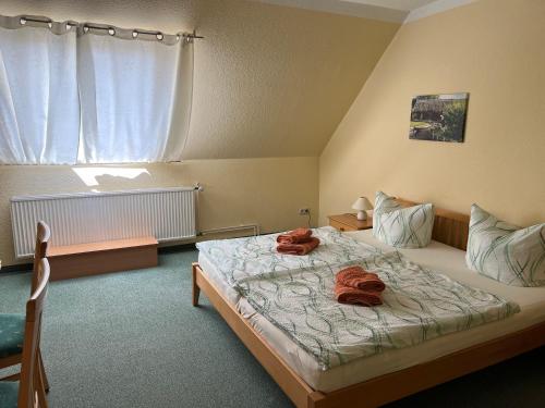 a bedroom with a bed with two towels on it at Pension Spreewaldstube in Vetschau