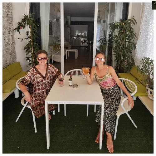 two women sitting at a table with drinks at Unique Sea & City Lifestyle Studio in Limassol