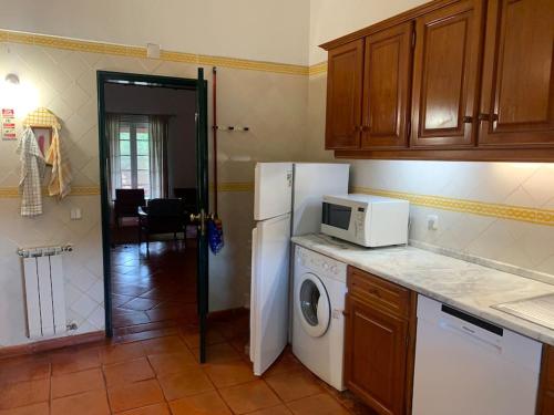 een keuken met een witte koelkast en een magnetron bij The S House - Santo Estêvão in Santo Estêvão