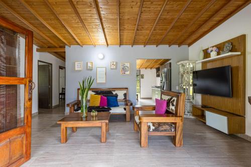 a living room with couches and a flat screen tv at Buho Cabaña Santa Elena in Santa Elena
