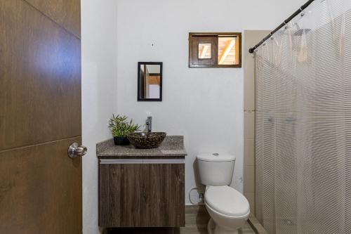 a bathroom with a toilet and a sink and a shower at Buho Cabaña Santa Elena in Santa Elena