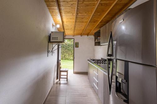 a hallway of a kitchen with a table and a chair at Buho Cabaña Santa Elena in Santa Elena