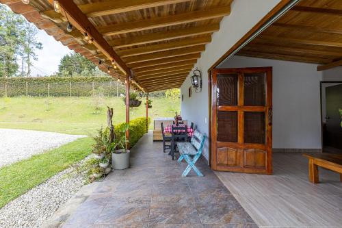 a patio with a wooden door and a table and chairs at Buho Cabaña Santa Elena in Santa Elena