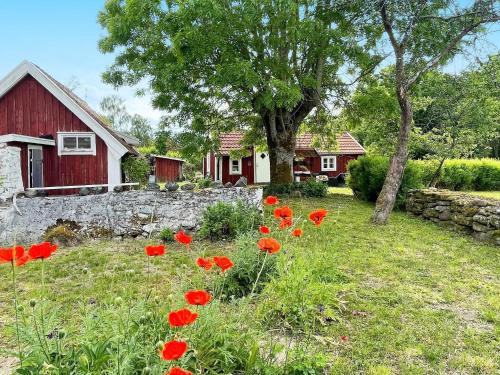 a field of red flowers in front of a house at 4 person holiday home in FÄRJESTADEN-By Traum in Färjestaden