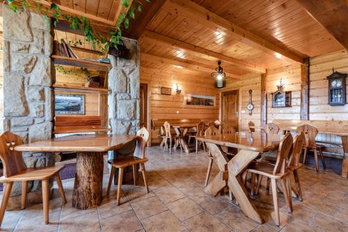 een eetkamer met houten tafels en stoelen bij Willa Jaroszówka in Kluszkowce