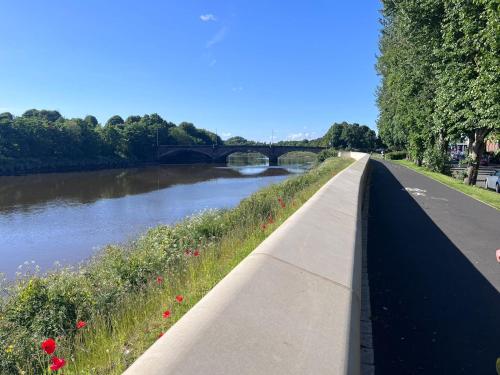 a path next to a river with a bridge at Riverside by Teil Luxurious one bed Apartment in Preston