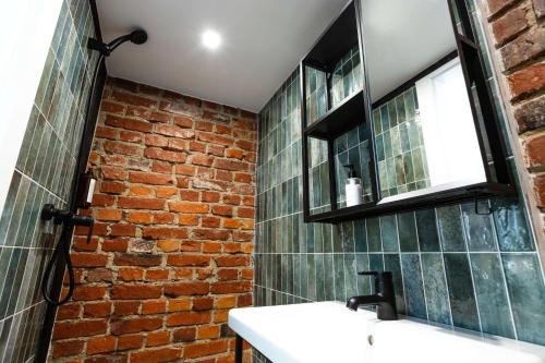 a bathroom with a brick wall and a sink at Old brick boutique apartments in Klaipėda