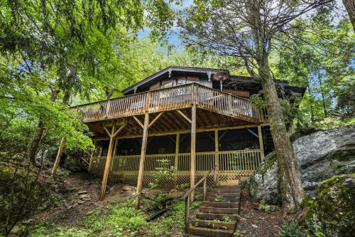 a house with a wrap around deck in the woods at Alpine Sanctuary in Valle Crucis