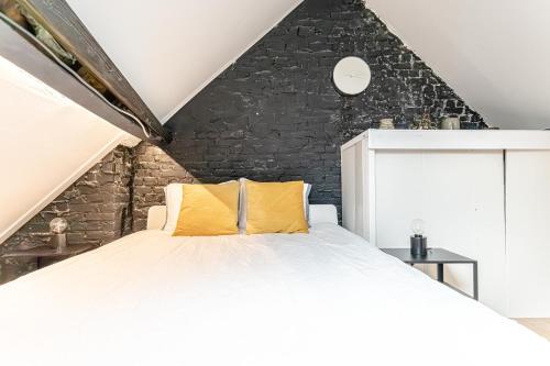 a bedroom with a large bed with yellow pillows at Spacious Shared 5BR Apt in the Heart of Gent in Ghent