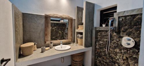 a bathroom with a sink and a stone wall at La VILLA BORAHA 300m2 PROPRIÉTÉ ENTIERE en bord de plage PISCINE PRIVEE Cuisine TV Wifi in Sainte Marie