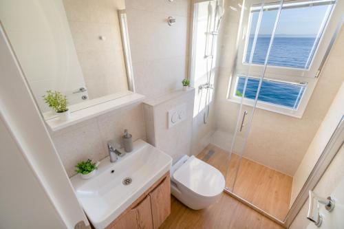 a bathroom with a sink and a toilet and a window at Apartments Malina in Tučepi