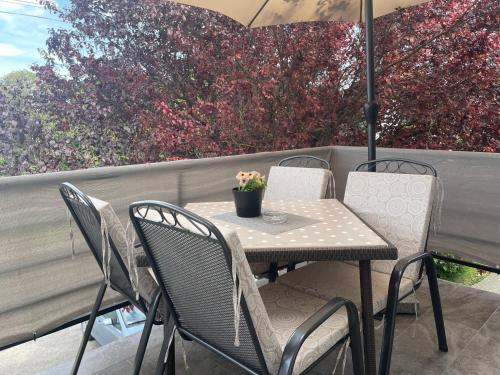 a table and chairs on a patio with an umbrella at Margaret Apartment in Balatonkeresztúr