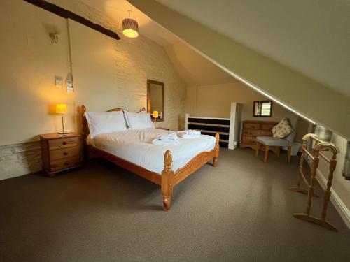 a bedroom with a large bed and a staircase at Courtyard Farm Cottages in Boscastle