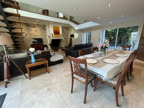 a dining room with a table and a living room at Le domaine de Brie in Châtillon-la-Borde