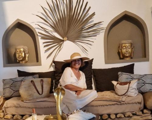 a woman sitting on a bed with heads on the wall at La VILLA BORAHA 300m2 PROPRIÉTÉ ENTIERE en bord de plage PISCINE PRIVEE Cuisine TV Wifi in Sainte Marie