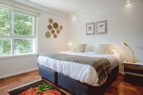 a bedroom with a bed and two windows at #NomadLife en Providencia Apartamento Flexible in Santiago
