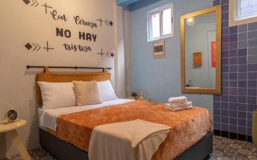 a small room with a bed and a mirror at Mala Vecindad Centro Historico in Mexico City