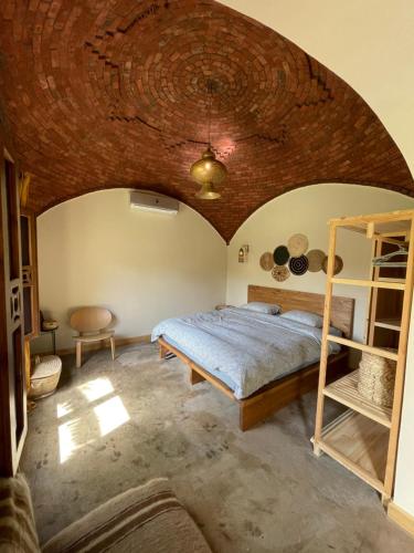a bedroom with a bed and a wooden ceiling at Mannam guesthouse & beautiful garden in Dahab