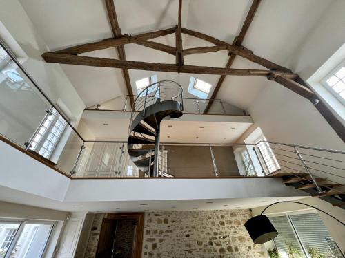 a spiral staircase in a building with windows at Le domaine de Brie in Châtillon-la-Borde