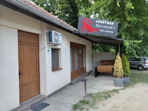 a sign on the side of a building with a bench at Scorpio Apartman/Sobe in Palić