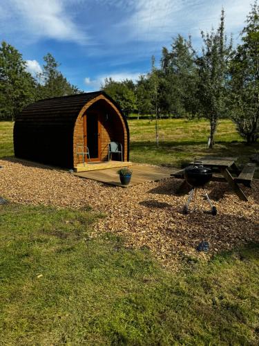 a small tent with a grill in a field at Howbeck Lodge in Hesket Newmarket