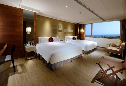 a large hotel room with two beds and a window at Shiny Ocean Hotel in Hualien City