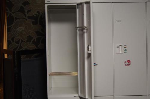 a refrigerator freezer sitting in a kitchen next to a wall at Guesthouse Tiga in Kumamoto