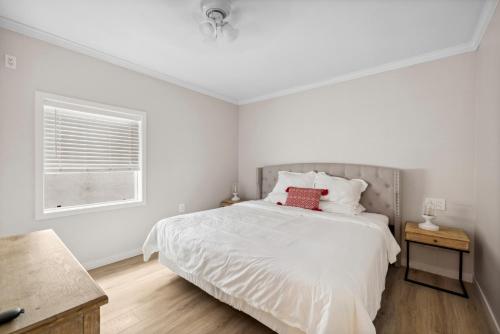 a white bedroom with a bed and a window at 1628 West Oceanfront Oasis - 4,6,7 in Newport Beach