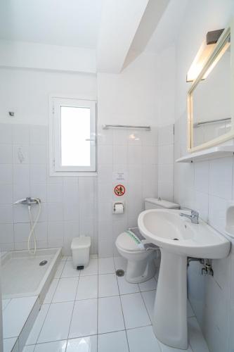 a white bathroom with a sink and a toilet at Fiore Di Mare Studios in Lassi