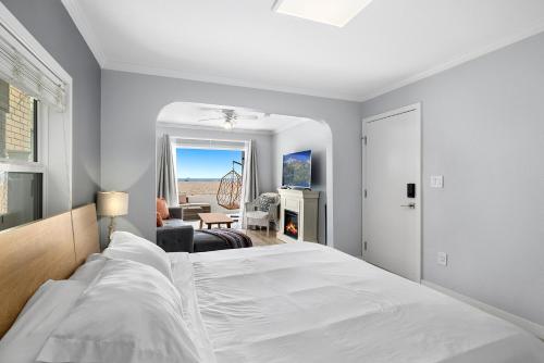 a bedroom with a white bed and a living room at 1628 West Oceanfront Oasis 2 in Newport Beach