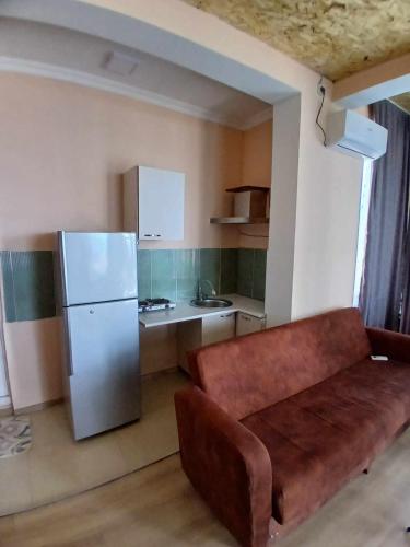a kitchen with a couch and a refrigerator at New Wave1 in Grigoleti