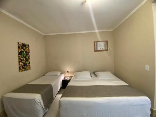 two beds in a small room with two beds sidx sidx sidx at Pousada Sol e Cia Tur in Caraguatatuba