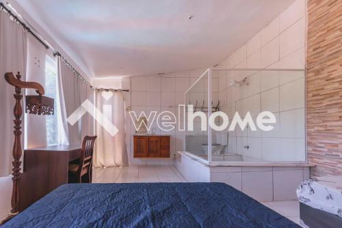 a bedroom with a bed and a bathroom with a sink at Casa com piscina em Buritama in Buritama