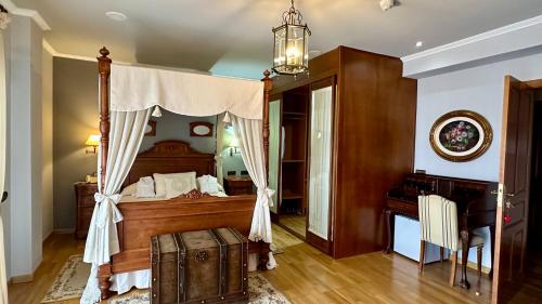 a bedroom with a canopy bed and a desk at Hotel El Curro in Burunchel
