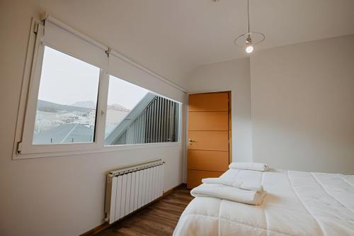 une chambre avec un lit et une grande fenêtre dans l'établissement Aunaisin - Toluken apartamentos, à Ushuaia